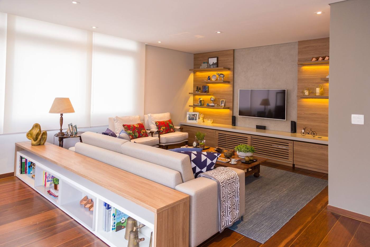 Sala de estar com nichos iluminados e painel de TV